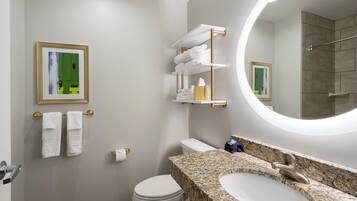 Un baño moderno con inodoro, lavamanos y toallero.