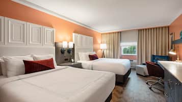 A hotel room with two beds, a desk, and a chair.