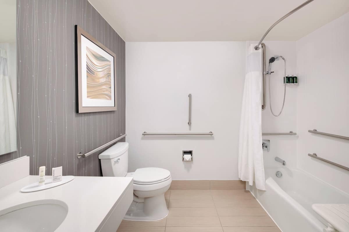 Een moderne badkamer met toilet, wastafel en bad.