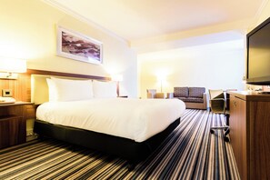 A hotel room with a large bed, a desk with a computer, a chair, and a television. - Holiday Inn Portsmouth by IHG (Portsmouth)