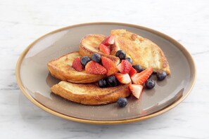 A plate of French toast with strawberries and blueberries. - Holiday Inn Portsmouth by IHG (Portsmouth)