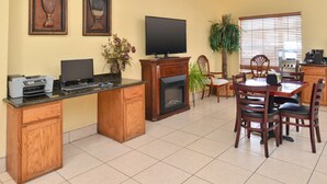 A kitchen with a dining area, a fireplace, a television, and a printer.