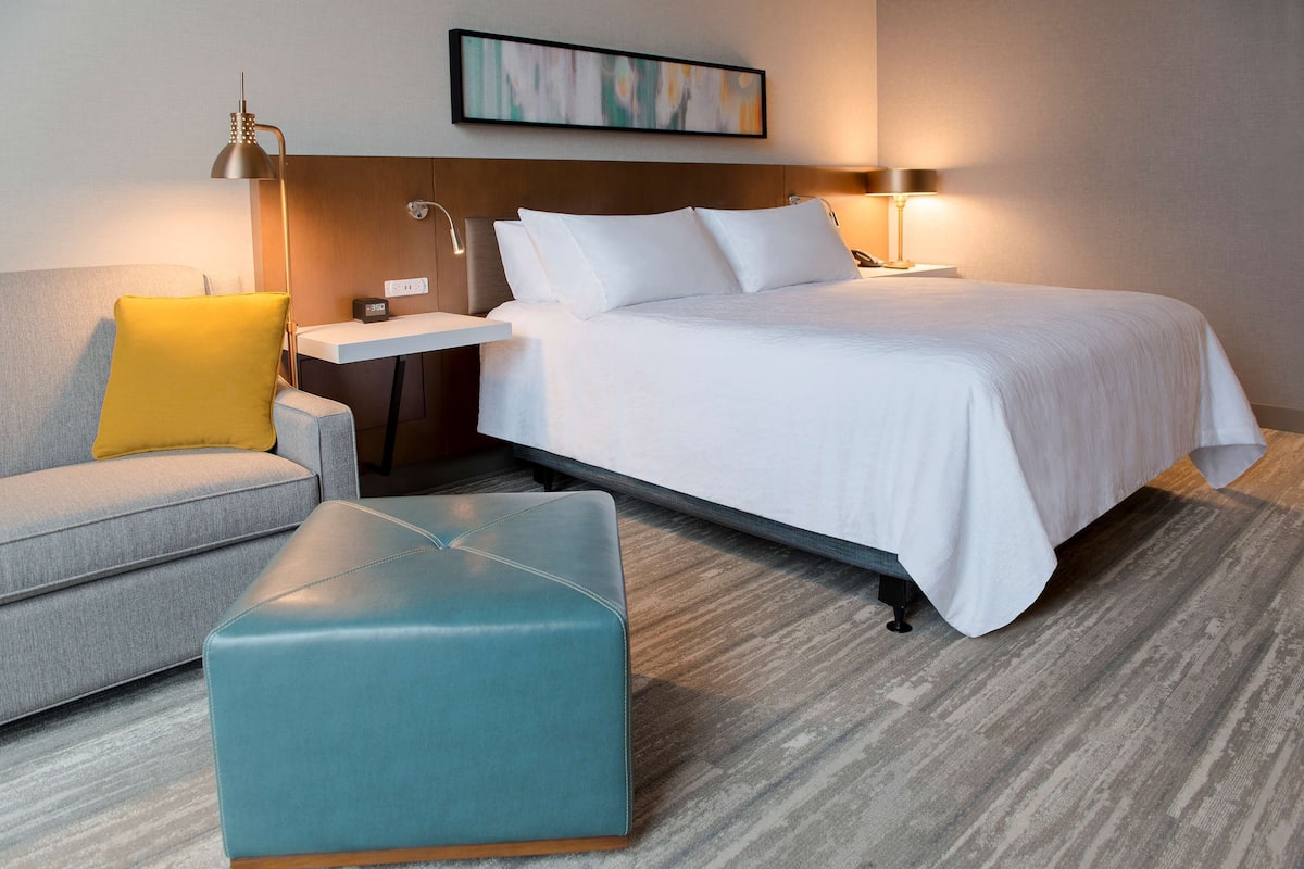 Une chambre d’hôtel avec un lit, un bureau, une chaise et un canapé.
