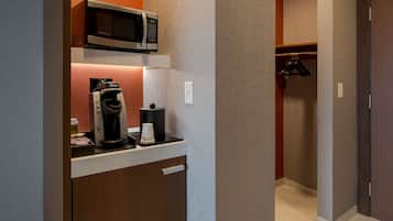 A compact kitchenette with a coffee maker, a microwave, and a small refrigerator.