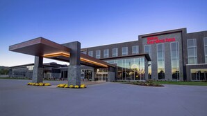 A modern hotel with a large entrance, a covered waiting area, and a prominent garden. - Hilton Garden Inn Wausau (Wausau)