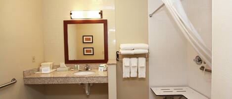 A bathroom with two sinks, a mirror, a towel rack, and a shower area.