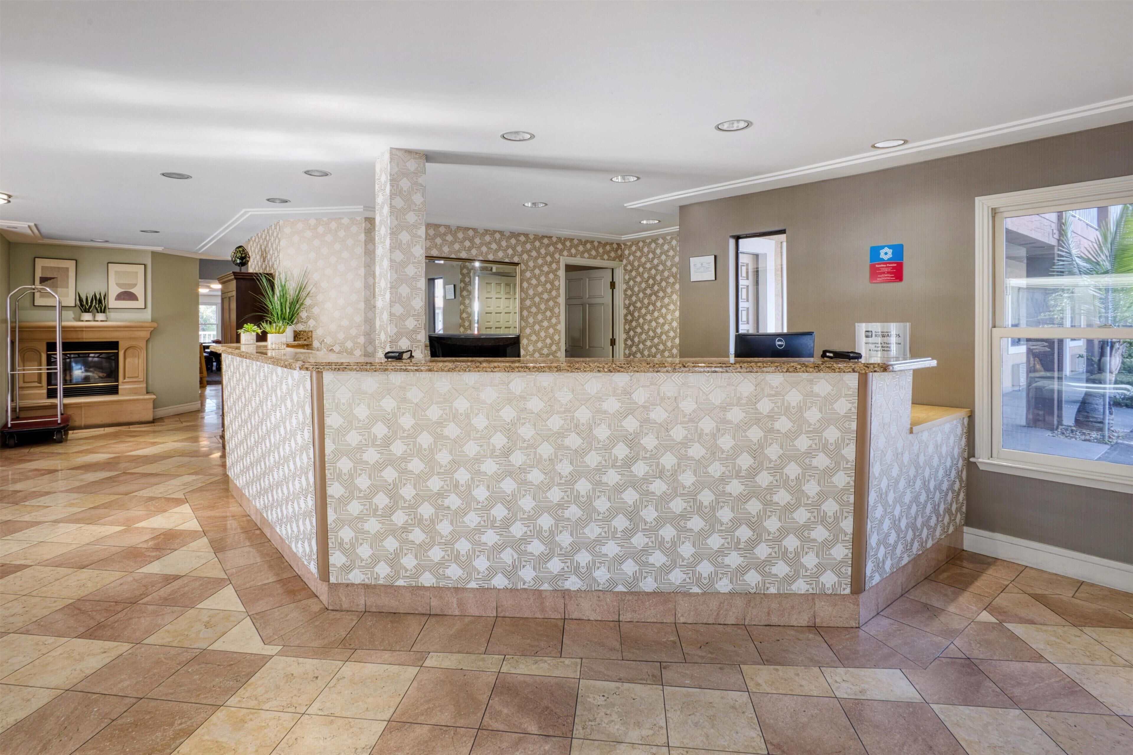 Un espace d’accueil doté d’un comptoir décoré, d’une cheminée et offrant une vue sur l’extérieur.