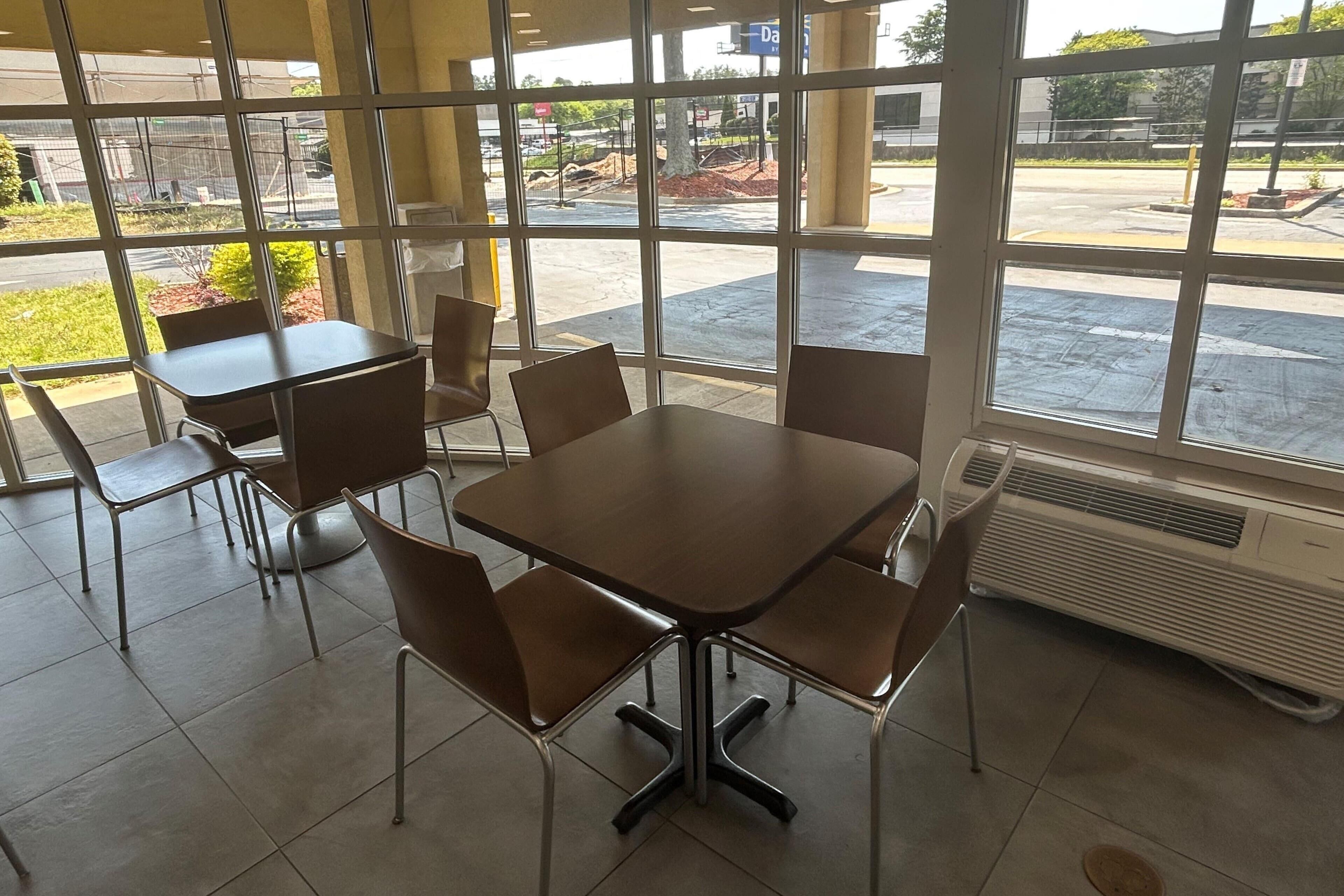 A conference room with a large table and chairs, large windows, and a visible air conditioning unit.