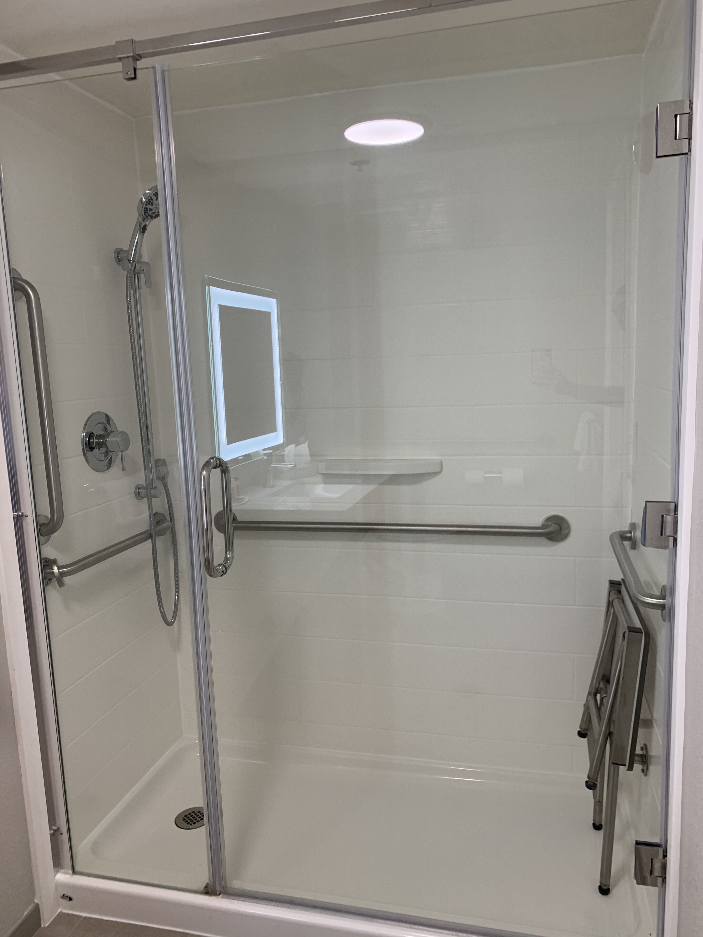 A glass-enclosed shower stall with a handheld showerhead, a handheld shower head, a handheld shower head, a handheld shower head, a handheld shower head, a handheld shower head, a handheld shower head, a handheld shower head, a handheld shower head, a handheld shower head, a handheld shower head, a handheld shower head, a handheld shower head, a handheld shower head, a handheld shower head, a handheld shower head, a handheld shower head, a handheld shower head, a handheld shower head, a handheld shower head, a handheld shower head, a handheld shower head, a handheld shower head, a handheld shower head, a handheld shower head, a handheld shower head, a handheld shower head, a handheld shower head, a handheld shower head, a handheld shower head, a handheld shower head, a handheld shower head, a handheld shower head, a handheld shower head, a handheld shower head, a handheld shower head, a handheld shower head, a handheld shower head,