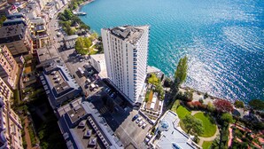 Een hoog hotel met uitzicht op een meer en bergen.