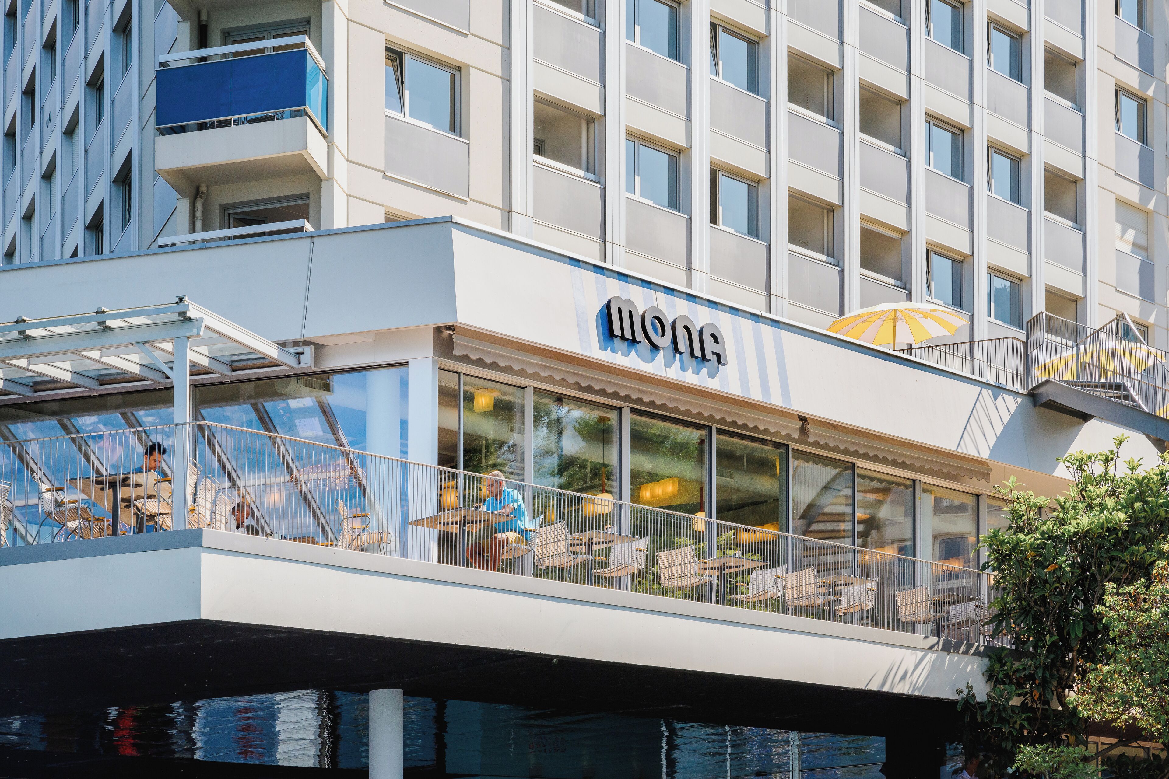 A modern building with a restaurant named "Mona" on the ground floor.