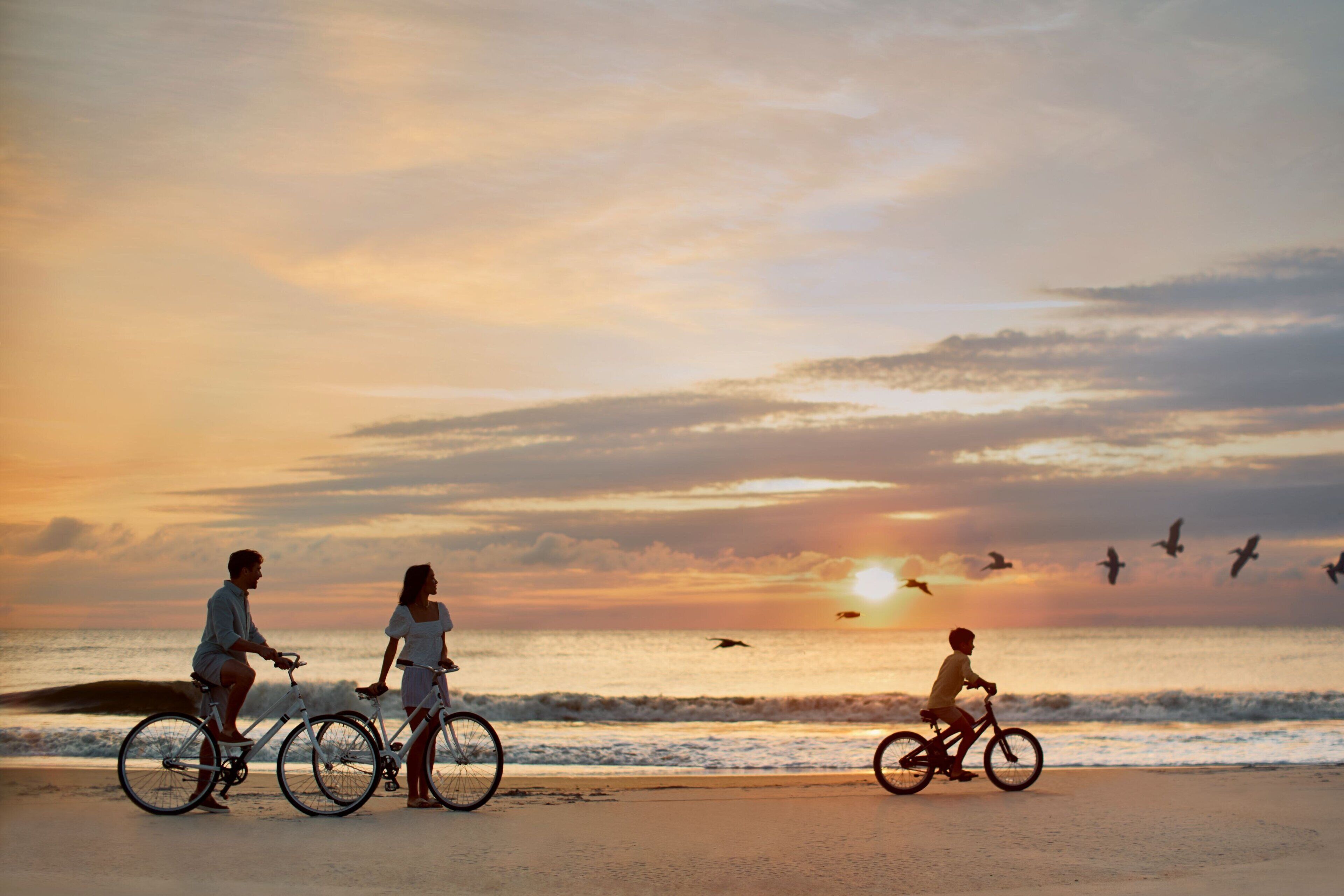 Une scène de plage où l’on voit des gens faire du vélo.