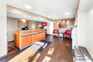 A reception area with a wooden counter, a digital kiosk, and a sign indicating free Wi-Fi.