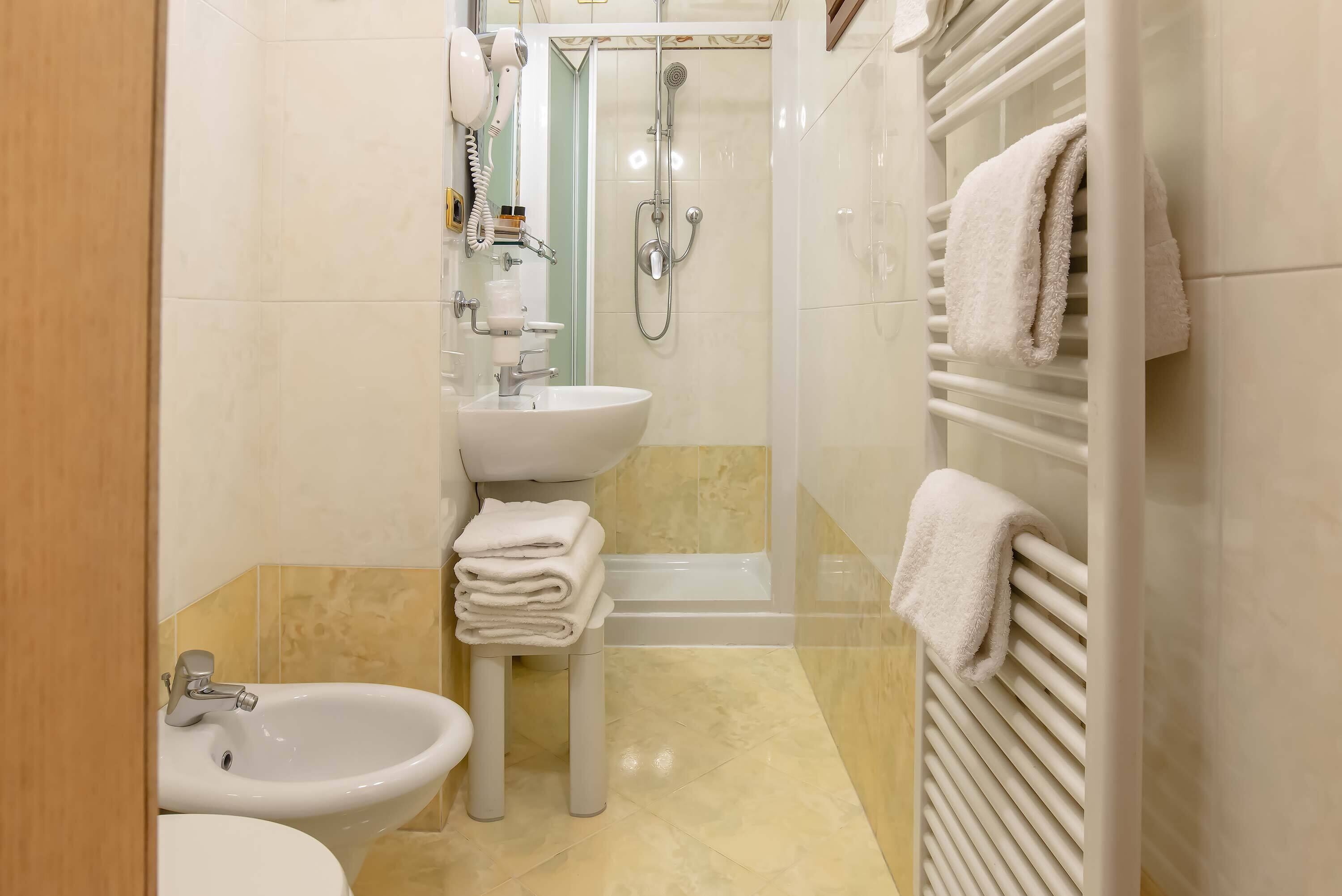 Un baño con lavamanos, bidé y ducha.