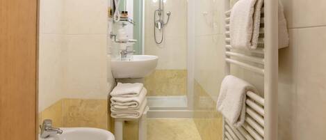 Un baño con lavamanos, bidé y ducha.