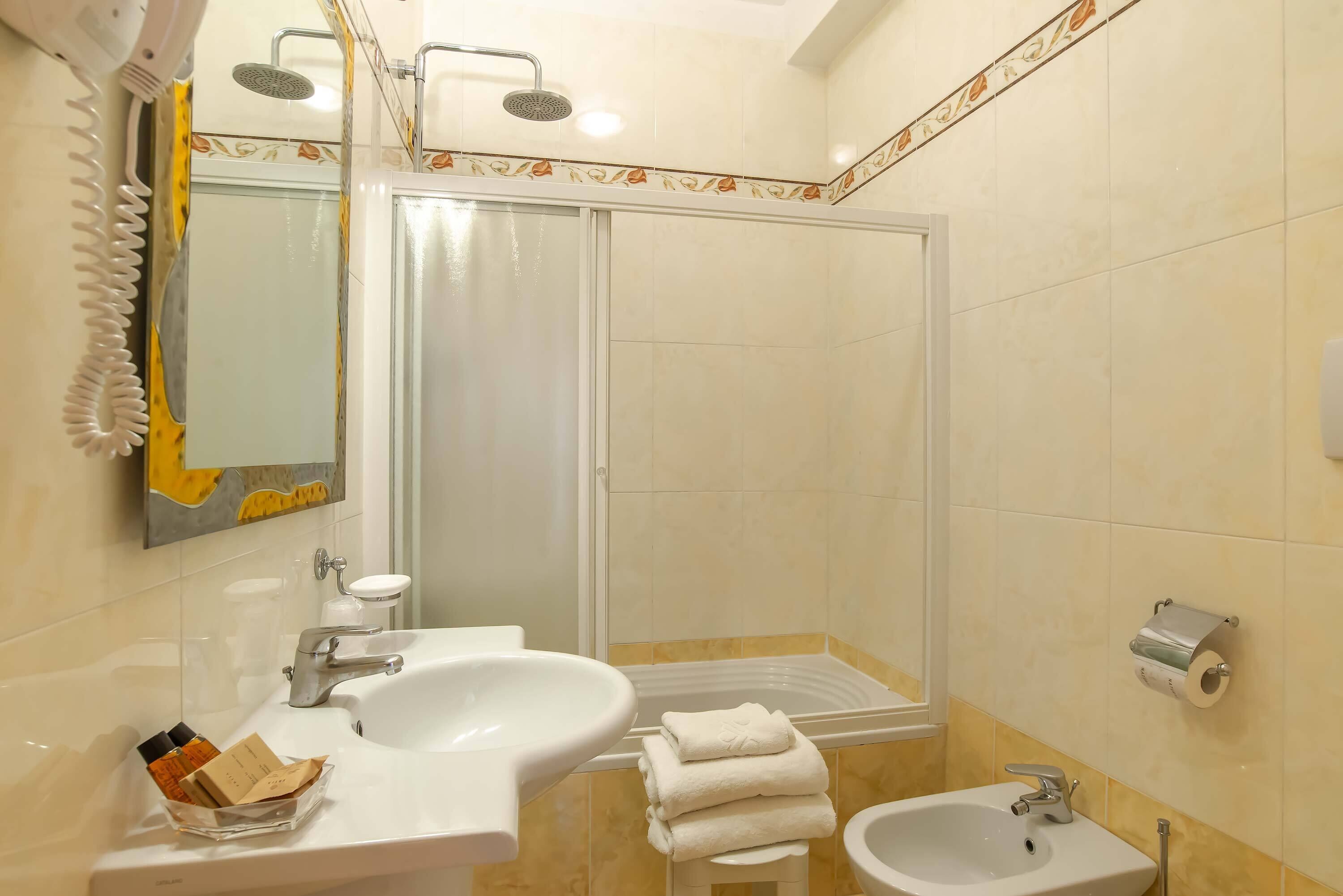 Un baño con ducha, lavabo y bidé.