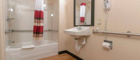 A bathroom with a bathtub, a shower, a sink, a toilet, and a mirror.