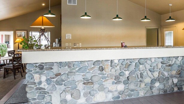 Un taulell de pedra amb llums penjants en un espai interior modern.