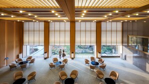 A spacious conference room with a high ceiling, large windows, and a view of the outdoors. - Hotel Okura Kobe (Kobe)