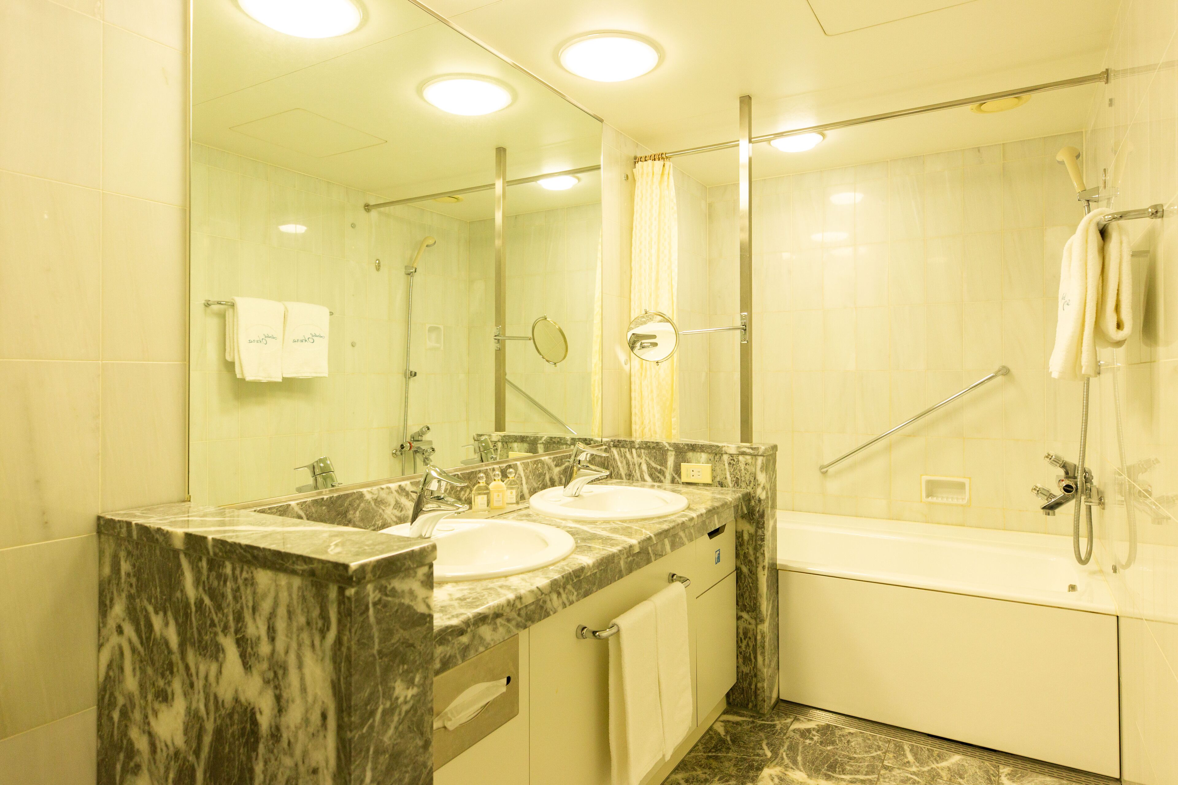Un baño con dos lavamanos, una bañera y una ducha.