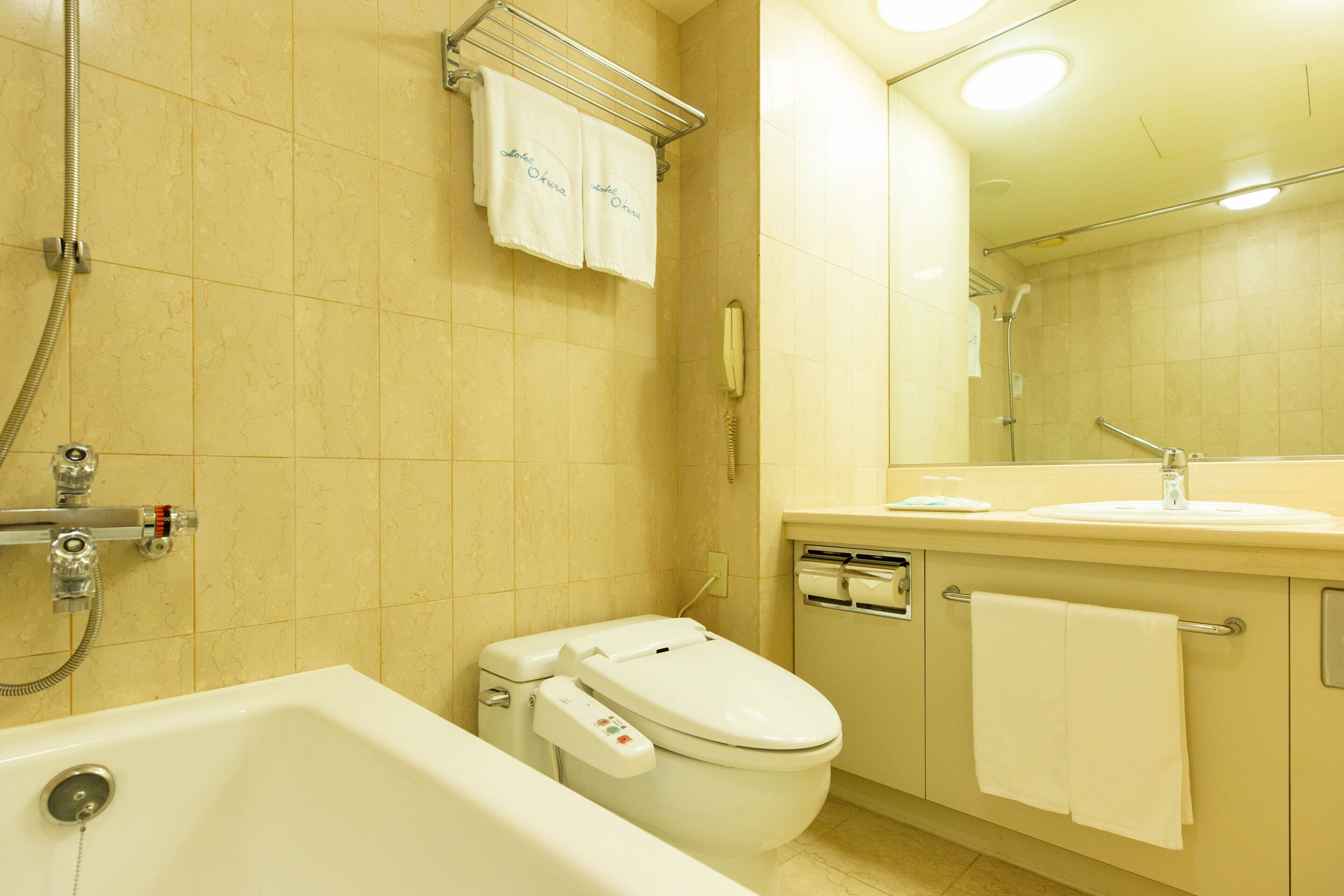 A bathroom with a bathtub, toilet, and sink.