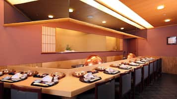 A long dining table set with multiple dishes and a mirror above it.