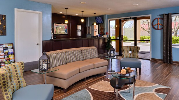 A modern lobby with a sofa, armchairs, a coffee table, and a reception desk. - Best Western Eunice (Eunice)