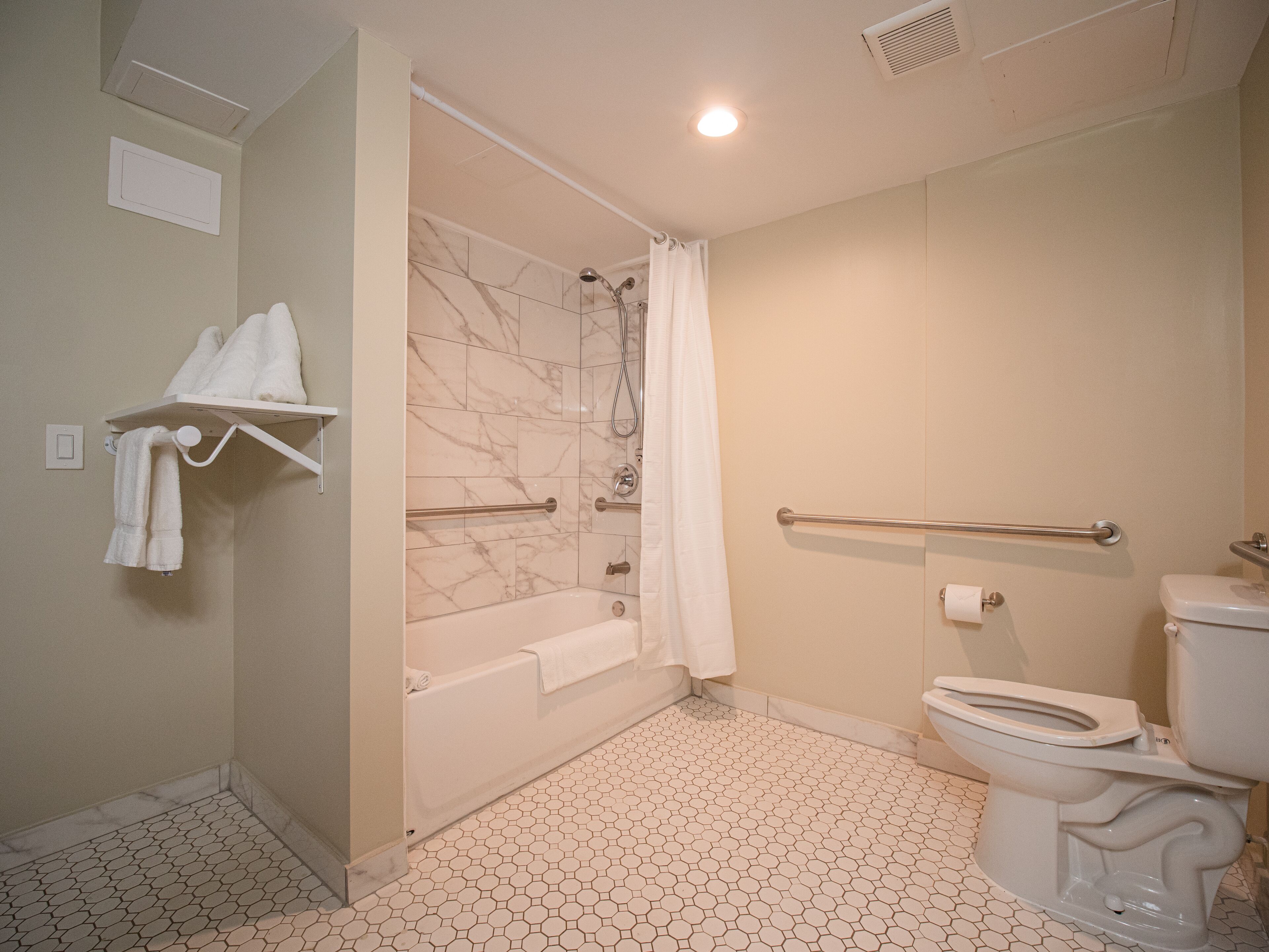 A bathroom with a bathtub, toilet, and shower.