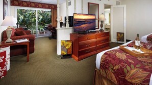 Une chambre d’hôtel équipée d’un lit, d’une télévision, d’un bureau, d’une chaise, d’une commode et offrant une vue sur l’extérieur.