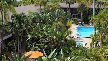 Un hotel con piscina rodeado de exuberante vegetación tropical.