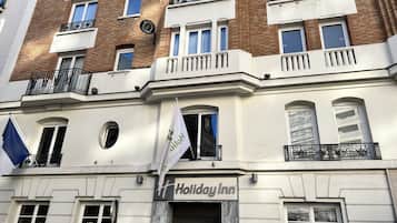 A Holiday Inn hotel with a classic facade, multiple balconies, and a prominent flag.
