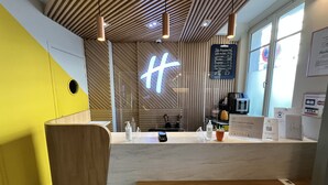A modern cafe interior with a wooden ceiling, a neon sign, a menu board, and a coffee machine.