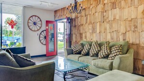 A modern interior with a wooden wall, a glass table, and a sofa with patterned cushions. - OYO Hotel Dundee By Crystal Lake (Dundee)