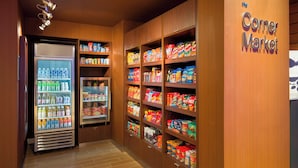 A corner market with refrigerated beverage dispensers and shelves stocked with snacks and groceries. - Fairfield Inn & Suites by Marriott Paramus (Paramus)