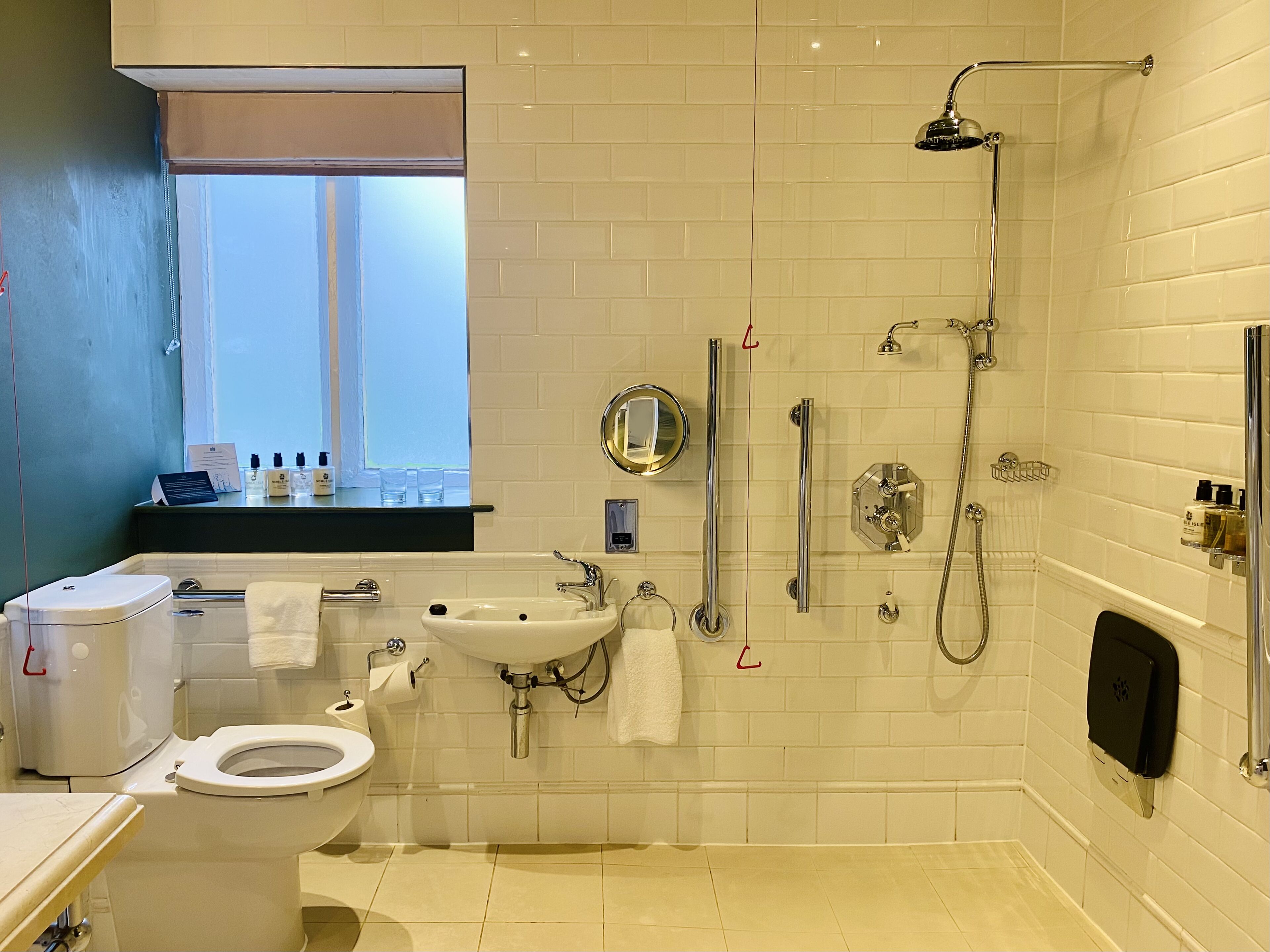 Un baño moderno con inodoro, lavamanos y ducha.
