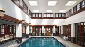 Una amplia piscina interior con vistas despejadas de los alrededores, incluyendo asientos y una escalera.