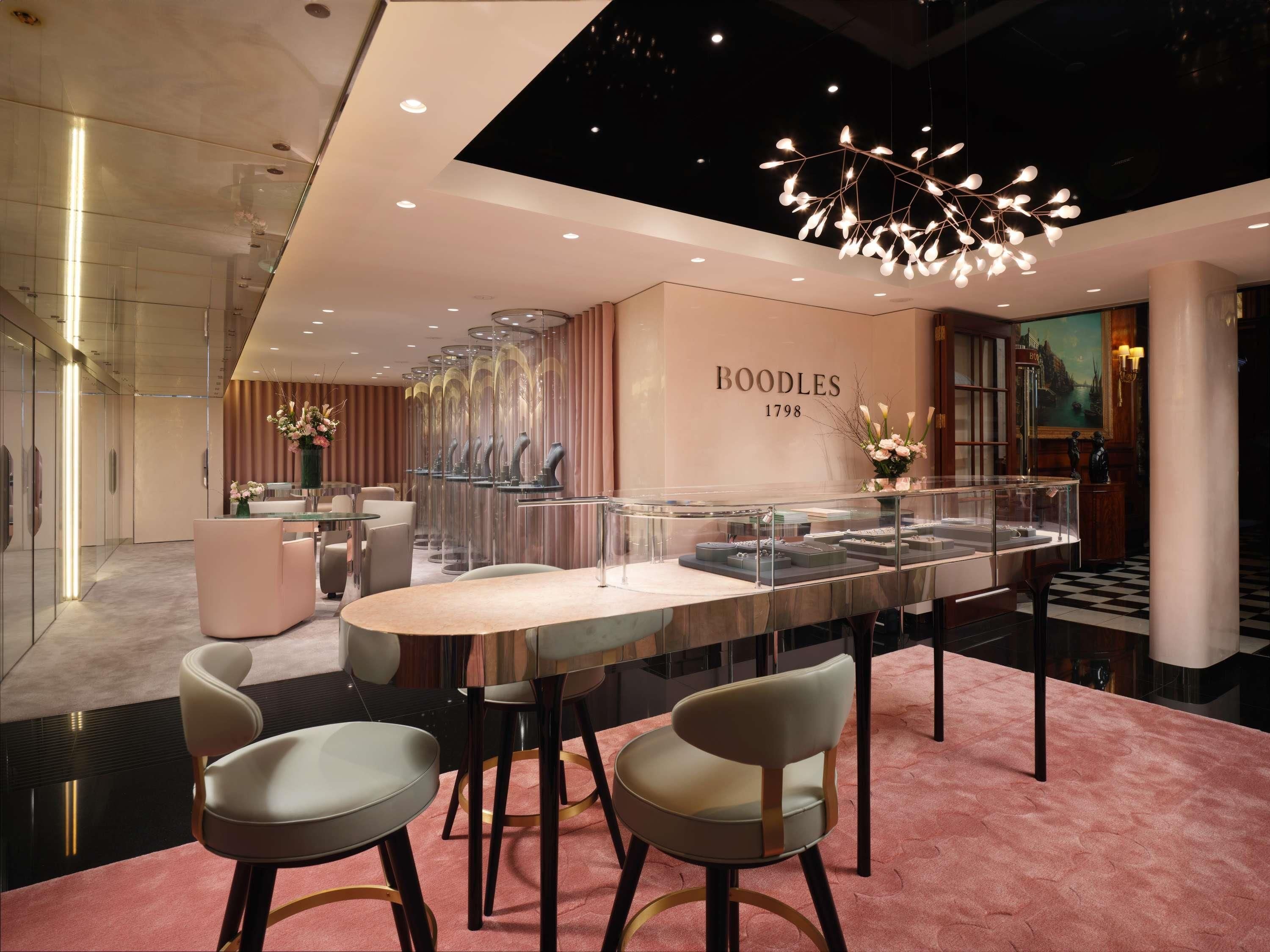 A modern interior with a glass display case, seating area, and a chandelier.