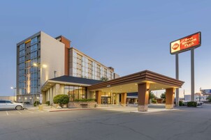 Un hotel con fachada moderna, un acceso cubierto y un llamativo letrero que anuncia 'Best Western Plus'.