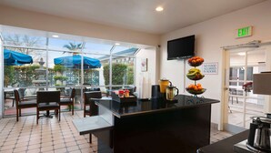 A restaurant with a glass partition, a black counter, and a sign indicating no food allowed in rooms. - Travelodge by Wyndham Bakersfield (Bakersfield)