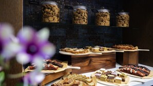 A buffet with various desserts and snacks, including brownies and cakes, displayed on wooden serving boards.