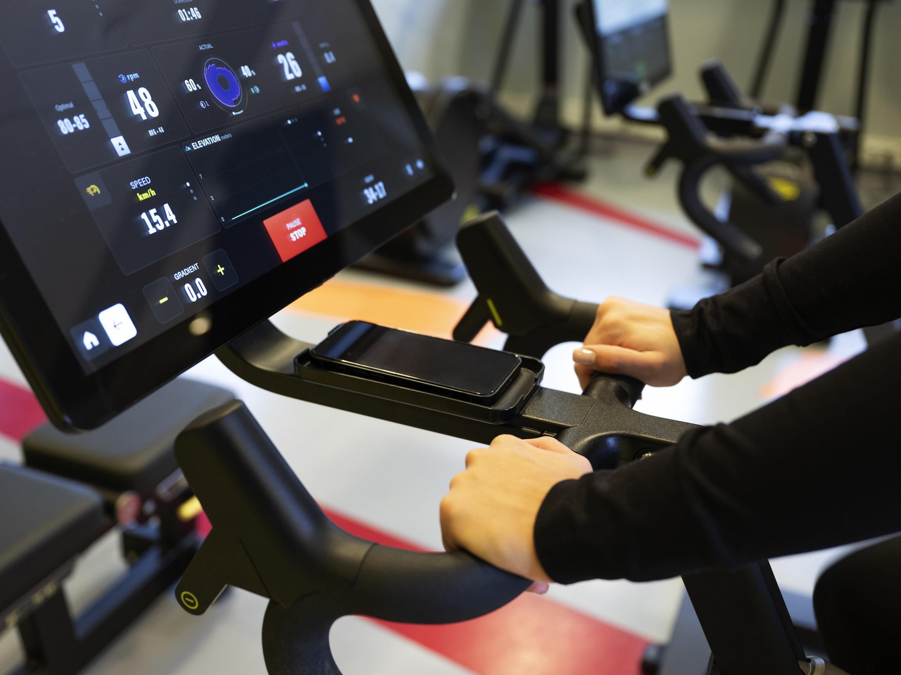 Una bicicleta estática con pantalla digital que muestra velocidad y otras medidas.