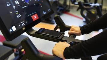Una bicicleta estática con pantalla digital que muestra velocidad y otras medidas.
