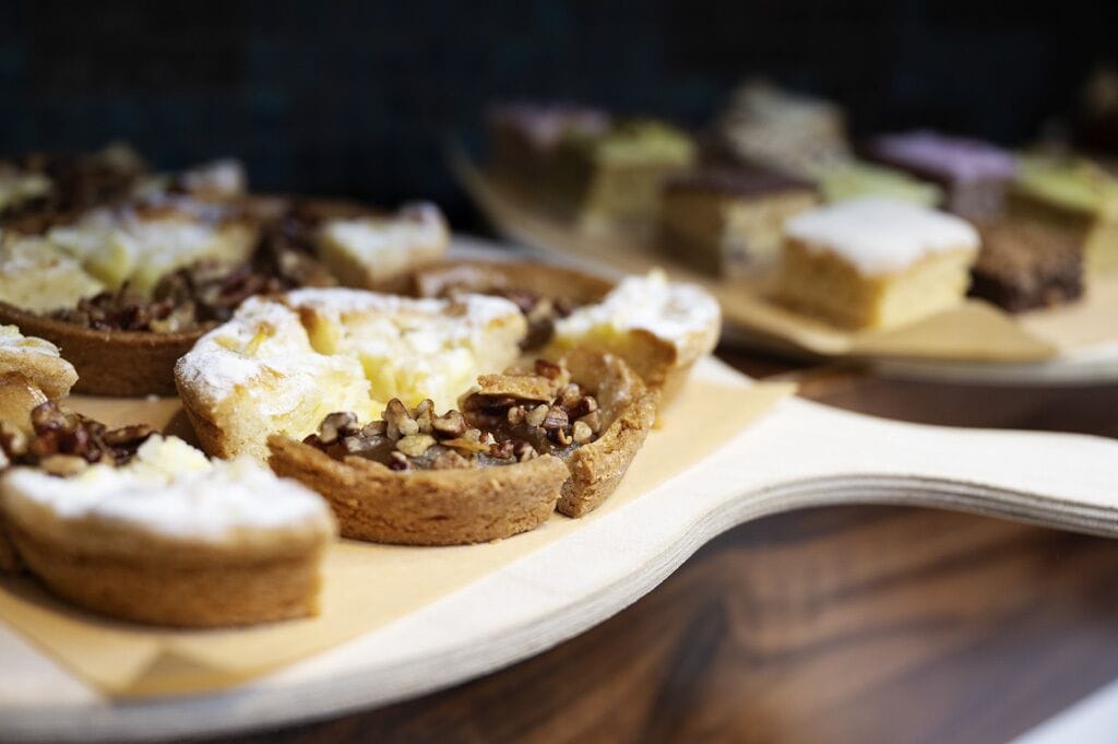 Una bandeja con diversos postres sobre una mesa de madera.