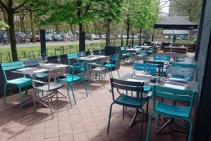 Enjoy al fresco dining amidst lush surroundings and a cozy seating area.
