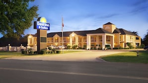 A Days Inn & Suites hotel with a large sign, multiple buildings, and a well-lit entrance.
