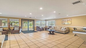 A spacious lobby with multiple seating areas, a reception desk, and large windows providing views of the outdoors. - Best Western Roseville Inn (Roseville)