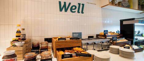 A breakfast buffet with various jams, pastries, and bread options.