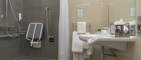 A modern bathroom with a shower, a toilet, a sink, and a towel rack.