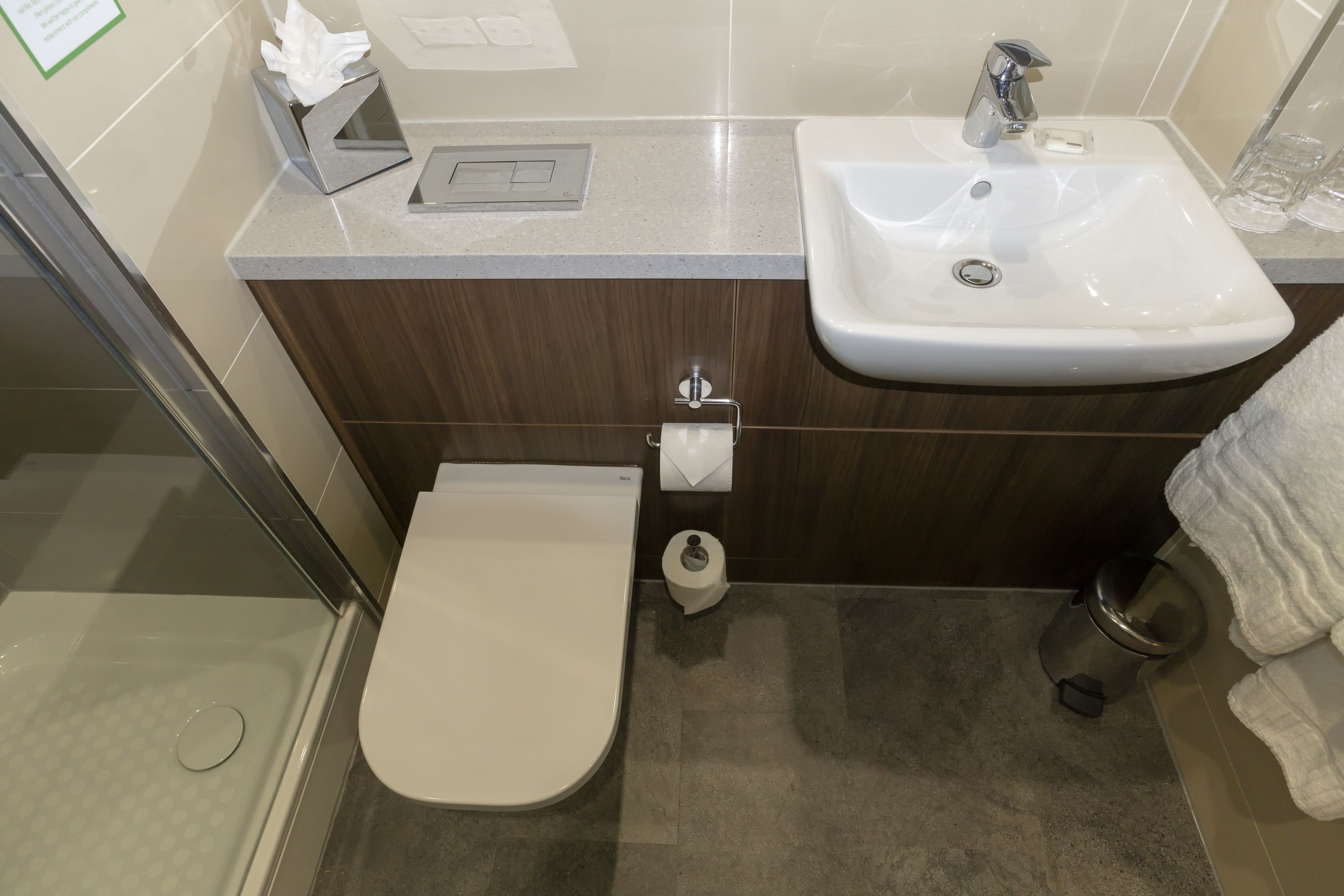 A bathroom with a toilet, sink, and shower.