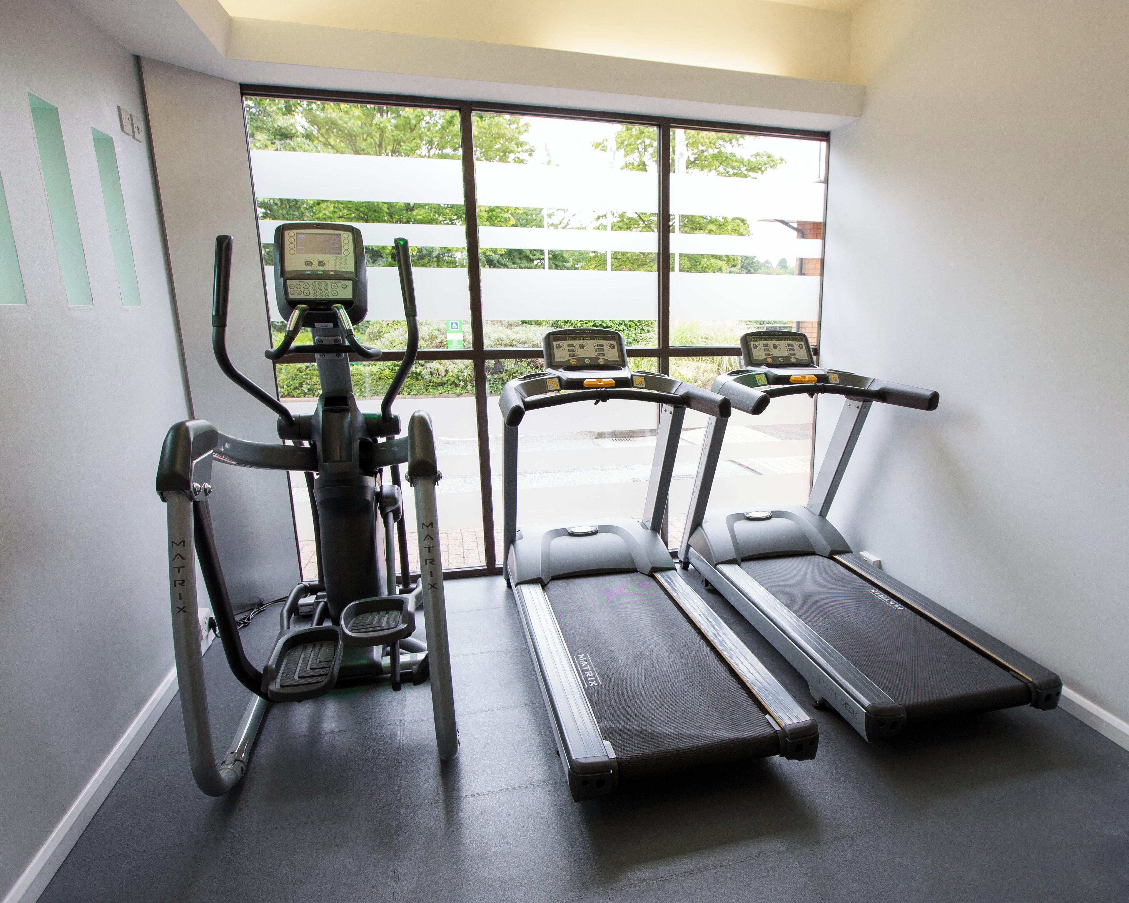 A gym with two treadmills and an elliptical machine.